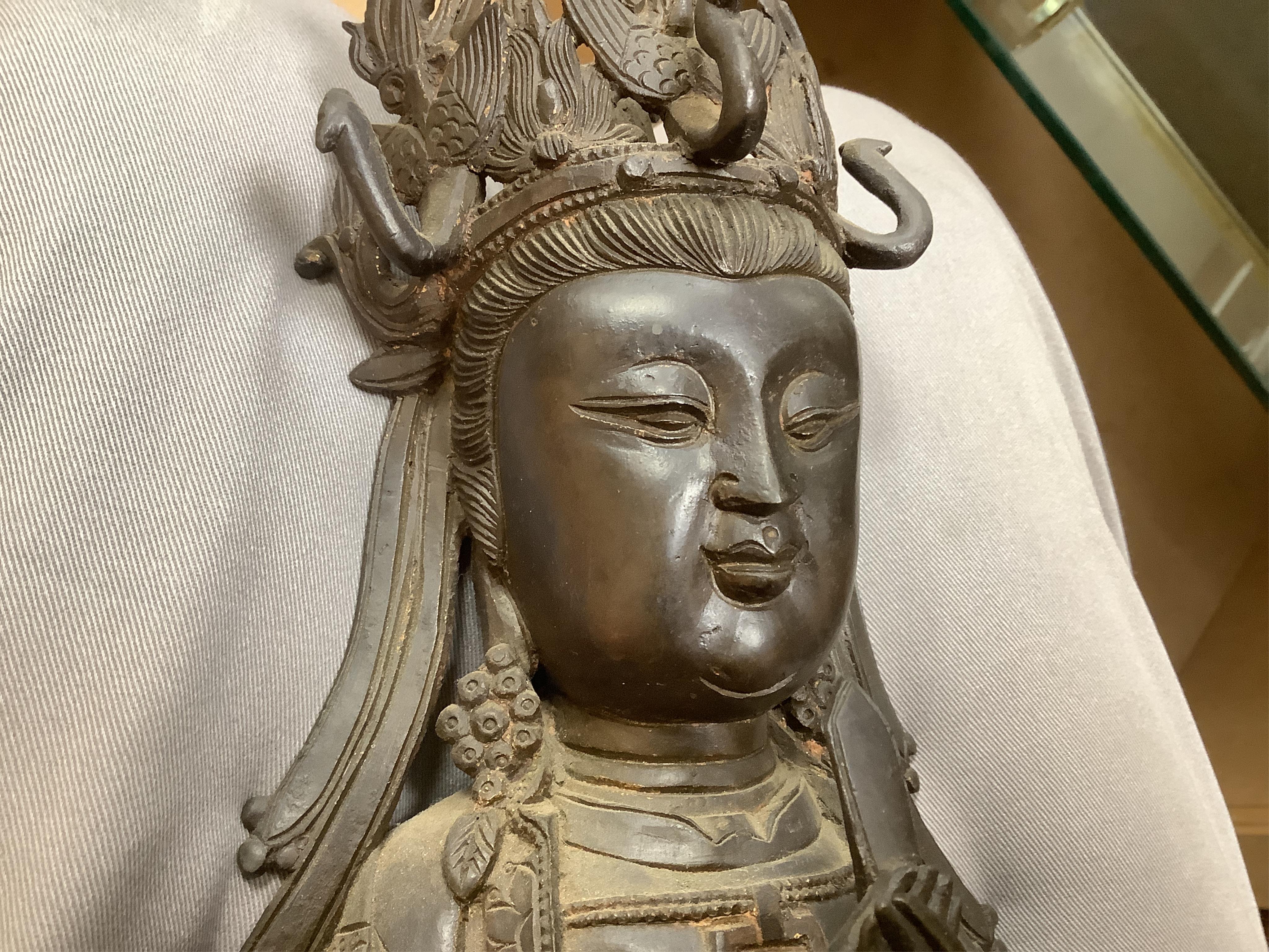 A Chinese late Ming bronze seated figure of Xi Wangmu, early 17th century (on stand). 34.5cm high not including stand.